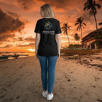 Woman wearing a black Deepwater Crew Co. cotton t-shirt with a nautical graphic on the back at a sunset beach.