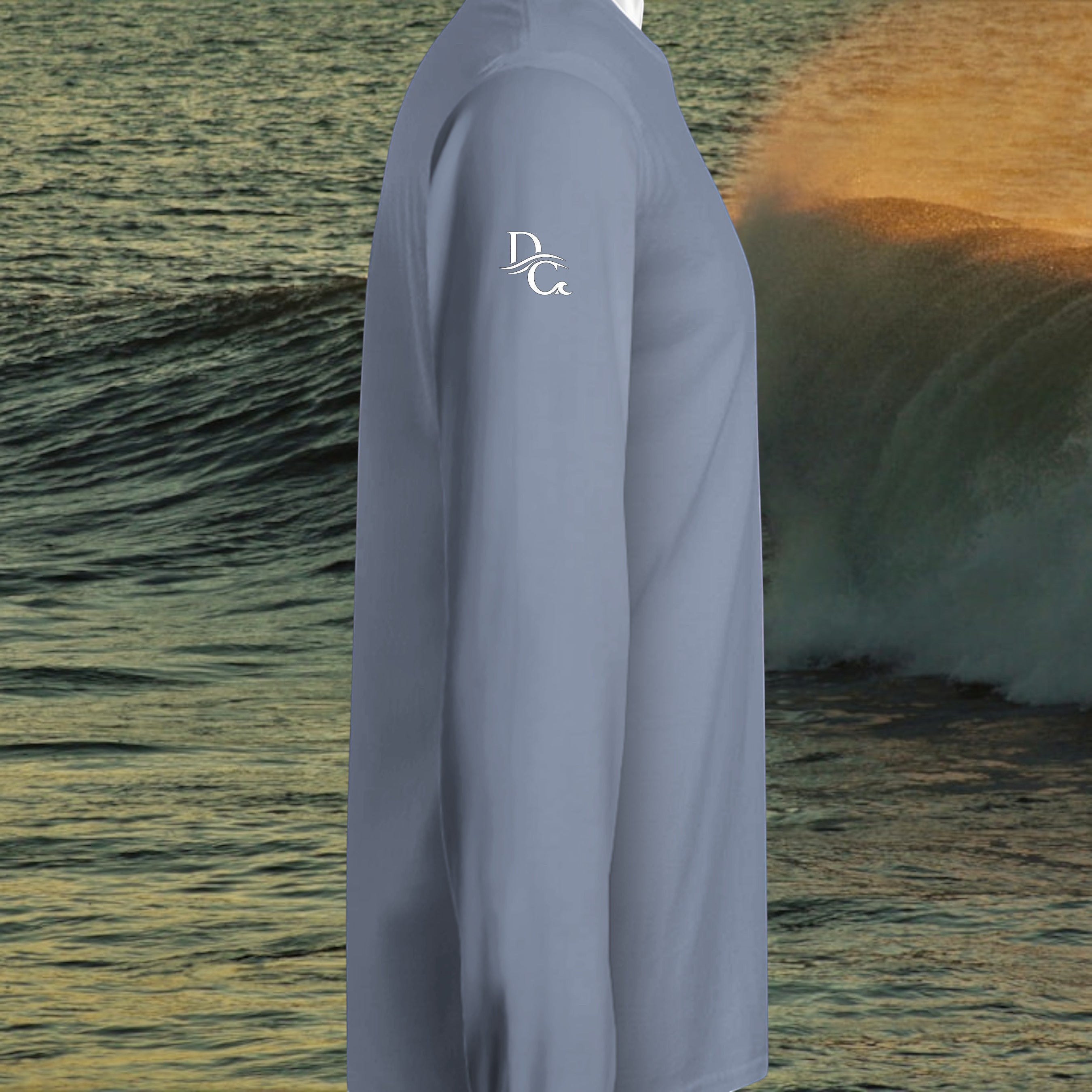 Deepwater Crew Co. blue garment-dyed long sleeve hooded t-shirt with white logo on sleeve against ocean wave backdrop