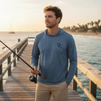 Deepwater Crew Co. blue tri-blend long-sleeve hooded tee with chest logo, worn by a man fishing on a pier.