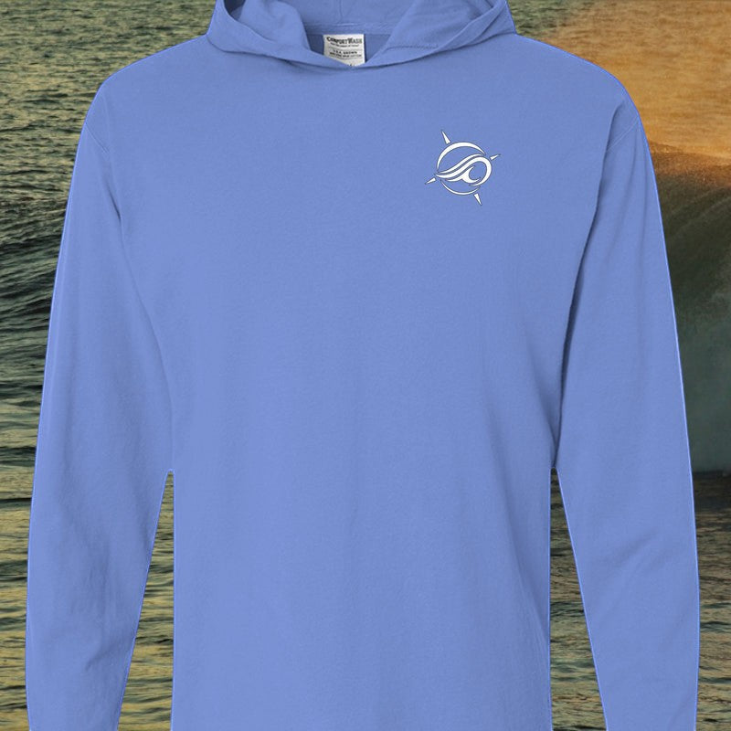 Deepwater Crew Co. blue garment-dyed long sleeve hooded t-shirt with white chest logo on a coastal water background