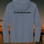 Deepwater Crew Co. blue tri-blend long sleeve hoodie with black logo on the back, set against a sunset coastal scene.