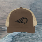 Deepwater Crew Co. brown cotton-polyester blend trucker hat with black wave logo and tan mesh back.