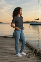 Woman wearing a Deepwater Crew Co. charcoal grey cotton crew neck t-shirt standing on a wooden dock at sunset.