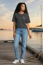 Deepwater Crew Co. charcoal grey cotton t-shirt with small white logo on chest worn by a woman on a wooden dock.