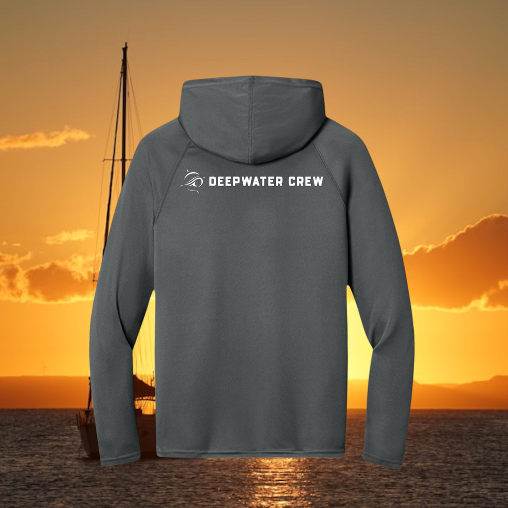 Deepwater Crew Co. dark grey performance UPF hoodie with white logo on back against a sunset ocean background