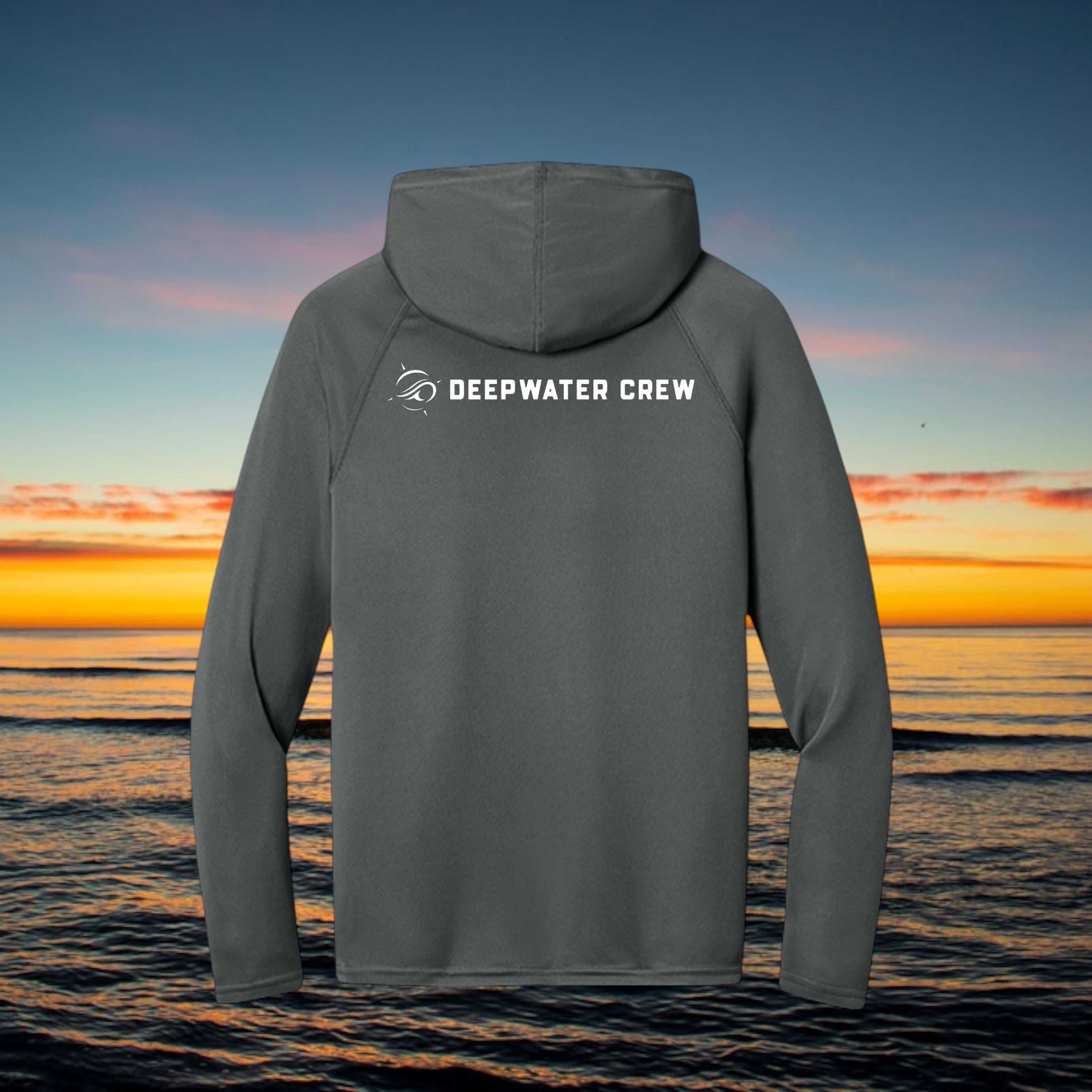 Deepwater Crew Co. dark grey performance UV hoodie with back logo against a sunset ocean background.