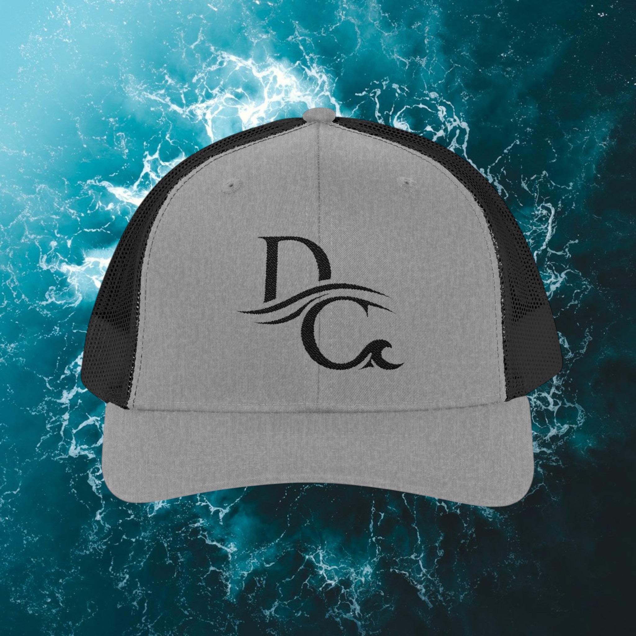 Deepwater Crew Co. grey and black trucker hat with embroidered DC wave logo. Cotton front, polyester mesh back.