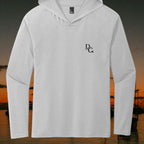 Deepwater Crew Co. light grey long sleeve tri-blend hoodie tee with a small black chest logo against a sunset background