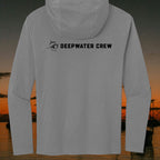 Deepwater Crew Co. grey tri-blend long sleeve hoodie with black logo on the back against a sunset coastal background.