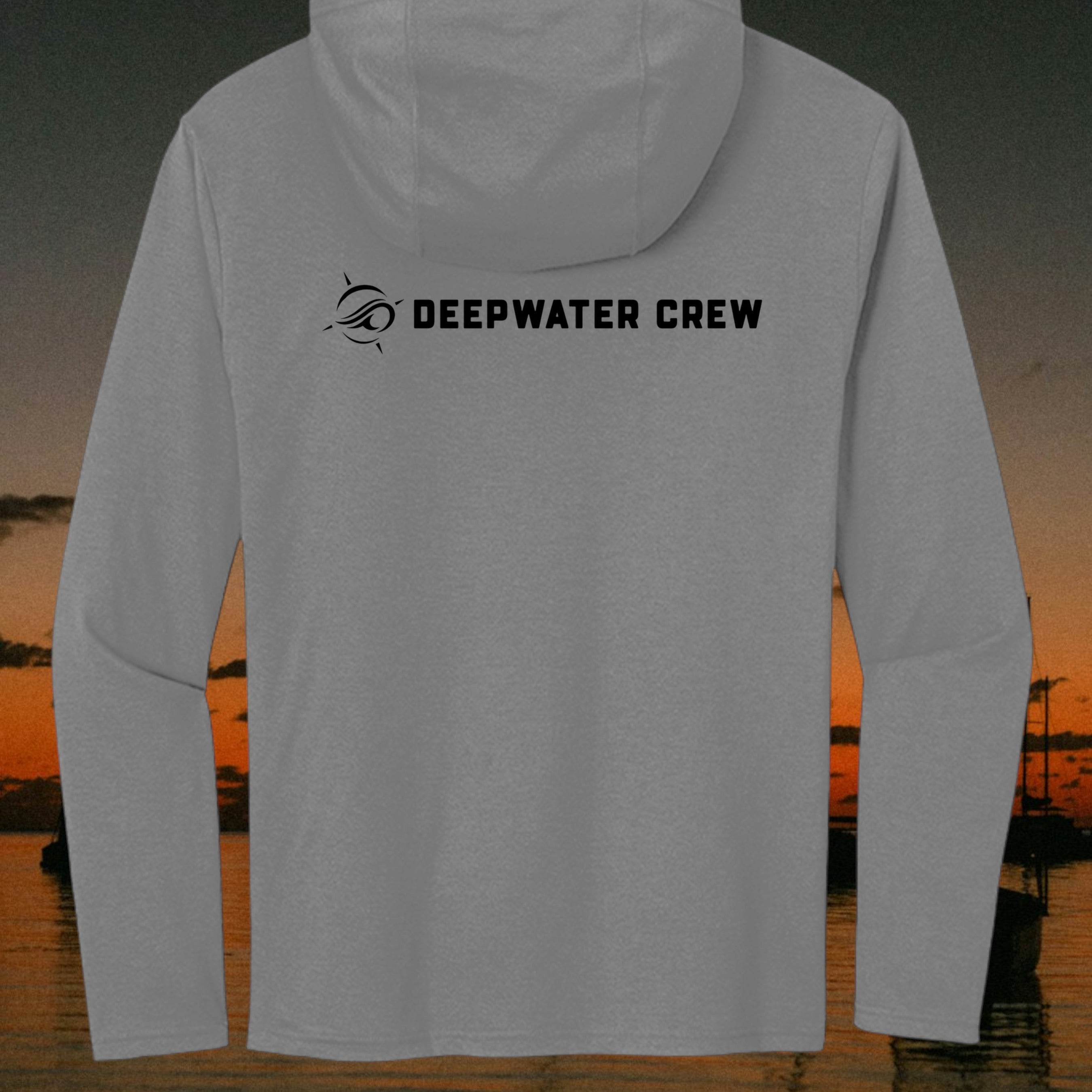 Deepwater Crew Co. grey tri-blend long sleeve hoodie with black logo on the back against a sunset coastal background.