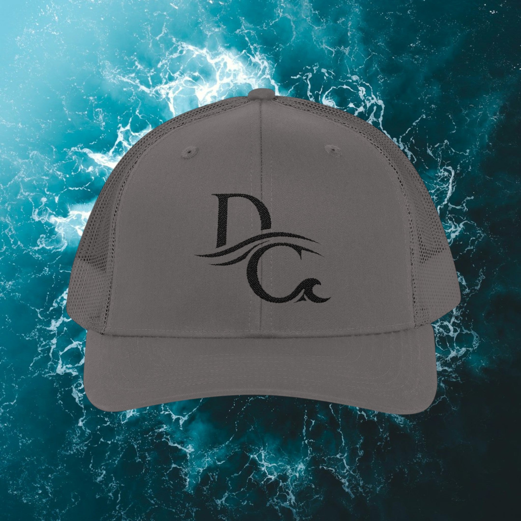 Deepwater Crew Co. grey trucker hat with embroidered DC wave logo. Structured front, mesh back, adjustable snapback.