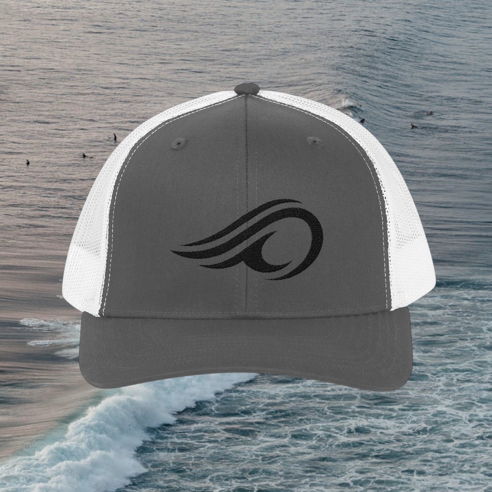 Deepwater Crew Co. dark grey trucker hat with white mesh back and black wave logo emblem. Adjustable snapback.