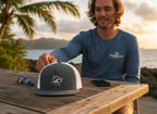 Deepwater Crew Co. grey and white trucker cap with flat bill and embroidered wave compass logo. Adjustable snapback.