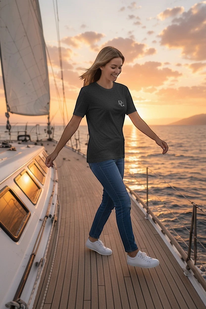 Deepwater Crew Co. dark heather grey crew neck tee with small white logo on chest, worn by a woman on a sailboat at sunset.