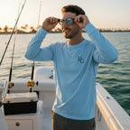 Deepwater Crew Co. light blue long-sleeve performance tee with UPF sun protection, worn by a man on a boat.