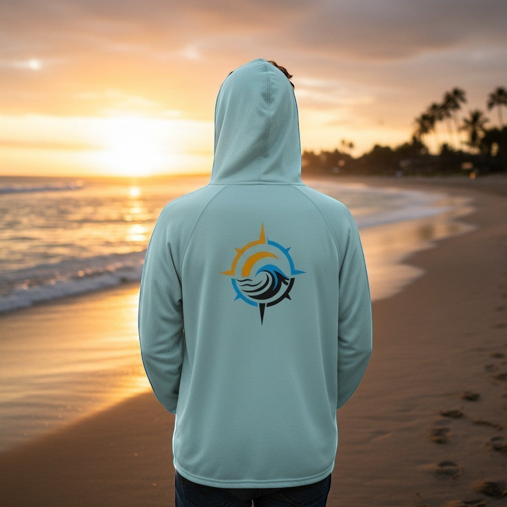 Deepwater Crew Co. light blue performance UPF hoodie with a compass wave logo on the back, worn by a man at sunset.