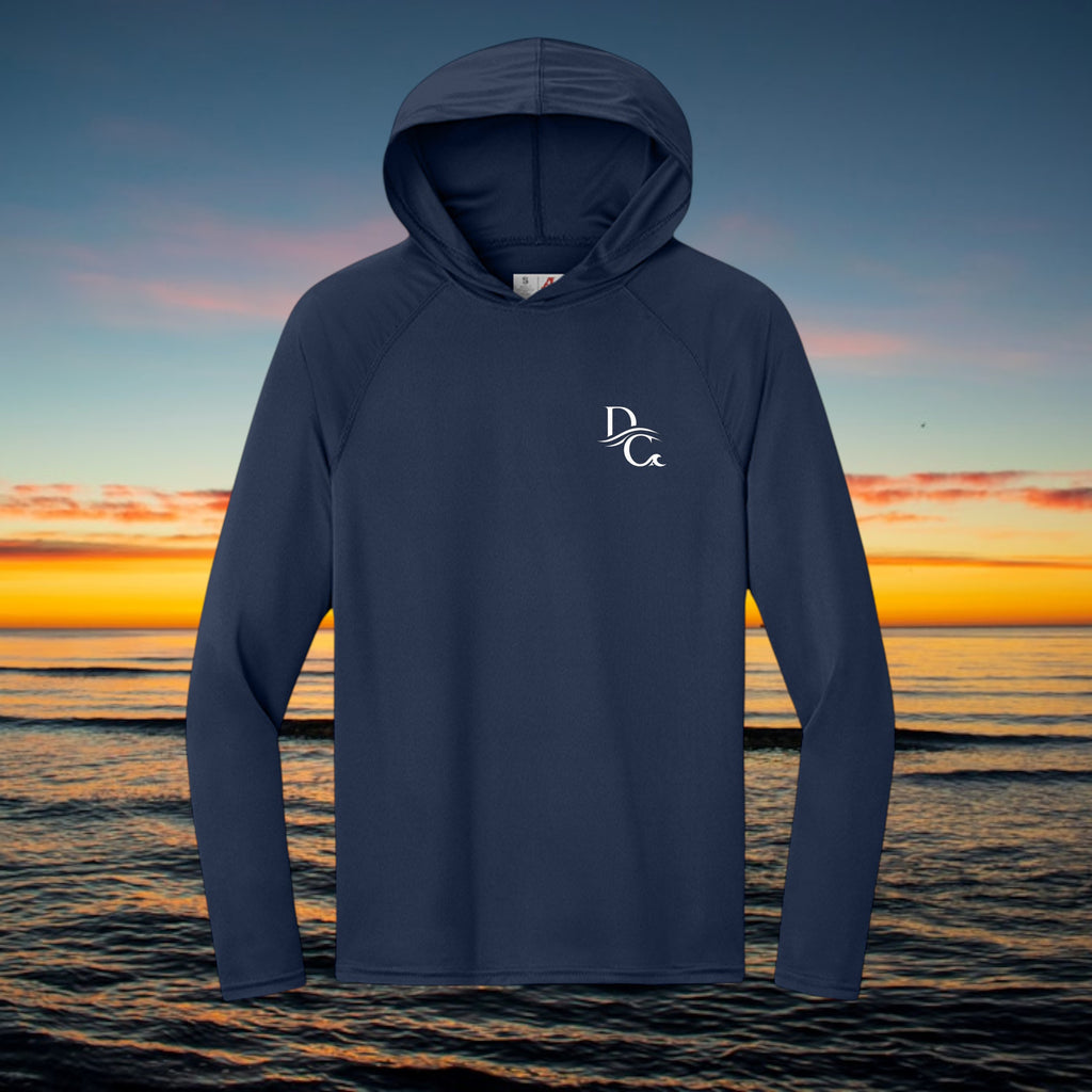 Deepwater Crew Co. navy blue performance UV hoodie with raglan sleeves and white logo against a sunset ocean backdrop