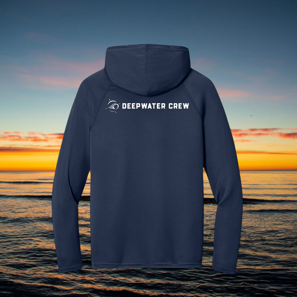Deepwater Crew Co. navy blue performance UV hoodie with white logo on back, set against an ocean sunset background.