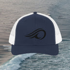 Deepwater Crew Co. navy blue and white trucker hat with black wave logo embroidery and adjustable snapback closure.