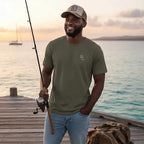 Deepwater Crew Co. man wearing an olive green cotton crew neck t-shirt with a small logo while fishing on a pier.