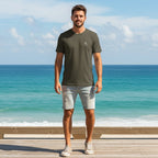 Deepwater Crew Co. olive green cotton crew neck t-shirt with small logo, worn by a man on a sunny beach boardwalk.