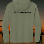 Deepwater Crew Co. olive green long sleeve tri-blend hoodie with black logo on the back against a sunset coastal backdrop