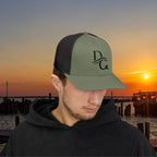 Deepwater Crew Co. olive green trucker hat with black mesh back and embroidered DC logo. Structured mid-profile design.