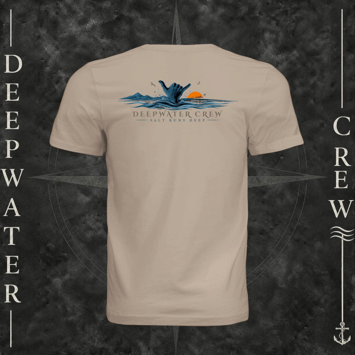 Dust Deepwater Crew Co. Salt Runs Deep crewneck T-shirt, back view with shaka hand, ocean waves, distant mountains, orange sunset, seabirds, and “Salt Runs Deep” lettering.