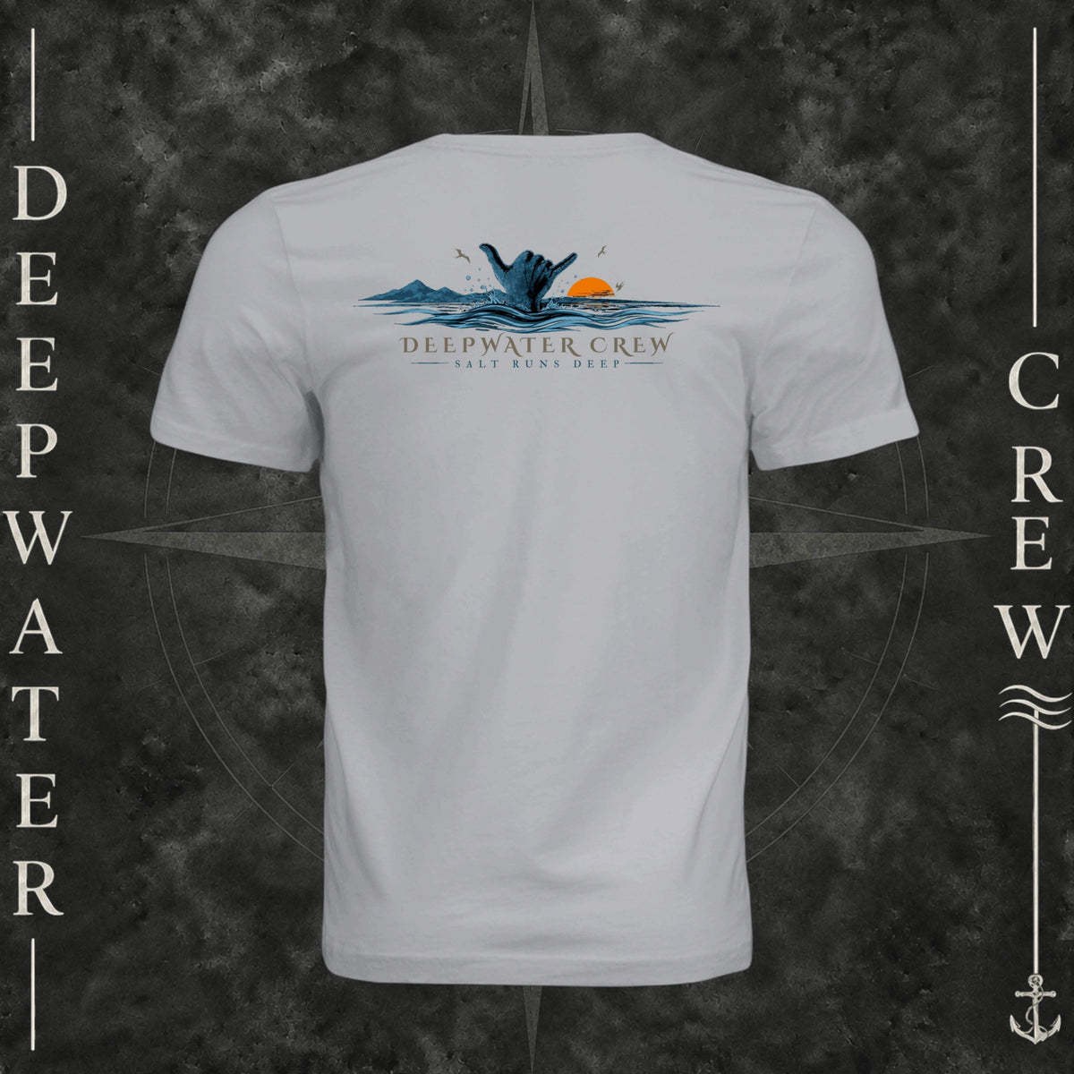 Solid Athletic Grey Deepwater Crew Co. Salt Runs Deep crewneck T-shirt, back view with shaka hand, ocean waves, distant mountains, orange sunset, seabirds, and “Salt Runs Deep” lettering.