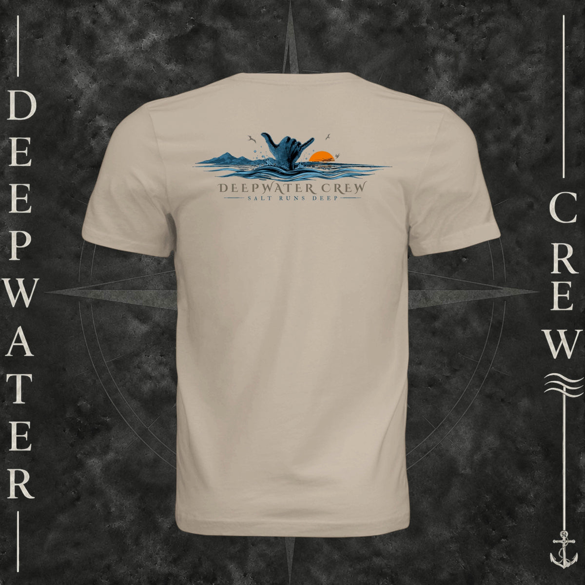 Tan Deepwater Crew Co. Salt Runs Deep crewneck T-shirt, back view with shaka hand, ocean waves, distant mountains, orange sunset, seabirds, and “Salt Runs Deep” lettering.