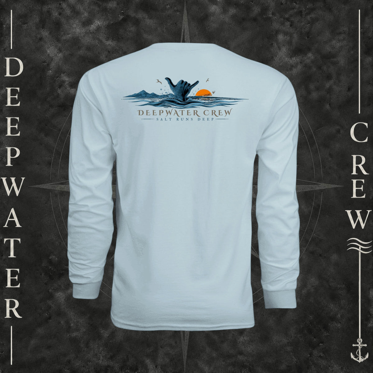 Pastel Blue Deepwater Crew Co. Salt Runs Deep UPF 44+ long-sleeve performance shirt, back view with shaka hand, ocean waves, distant mountains, orange sunset, seabirds, and “Salt Runs Deep” lettering.