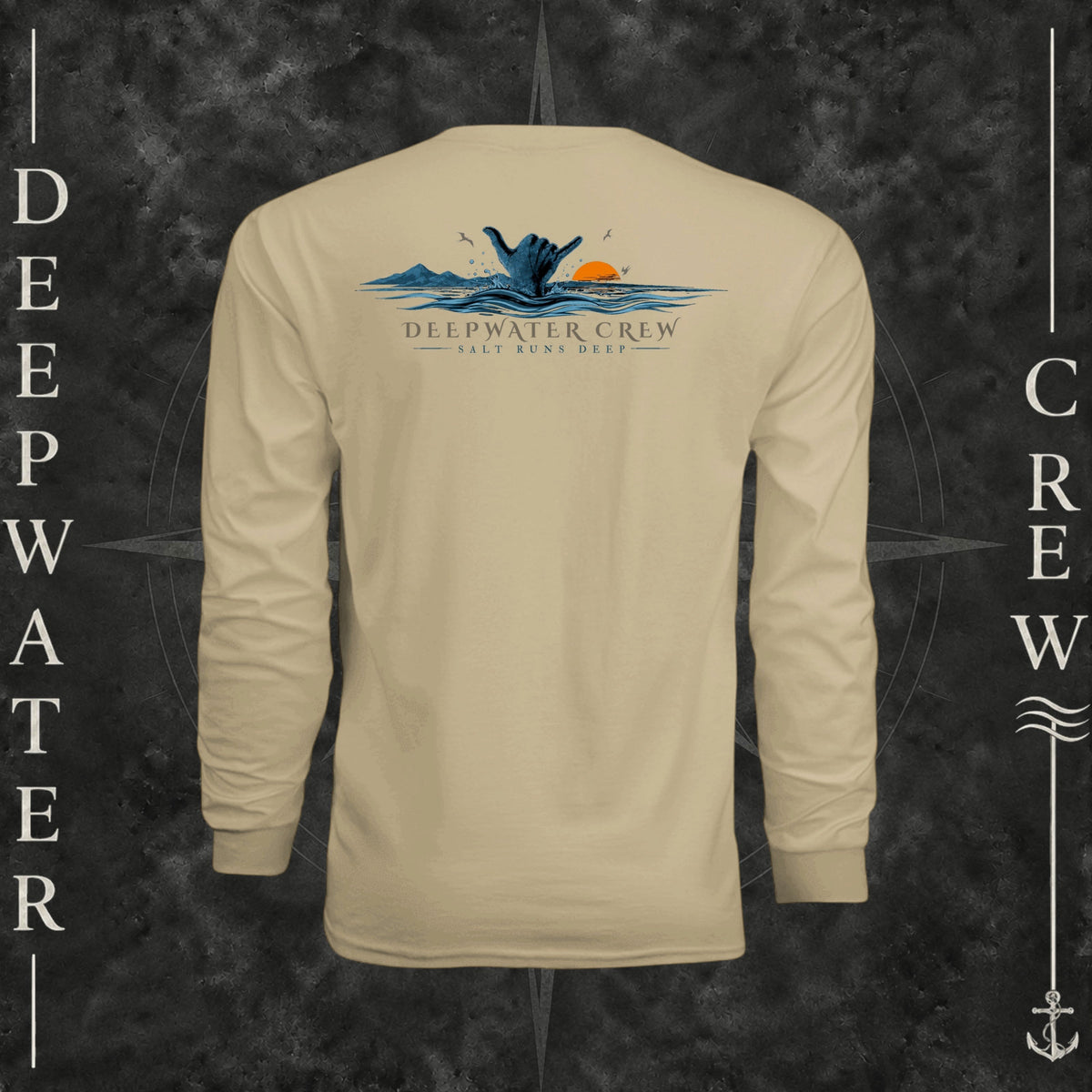 Sand Deepwater Crew Co. Salt Runs Deep UPF 44+ long-sleeve performance shirt, back view with shaka hand, ocean waves, distant mountains, orange sunset, seabirds, and “Salt Runs Deep” lettering.