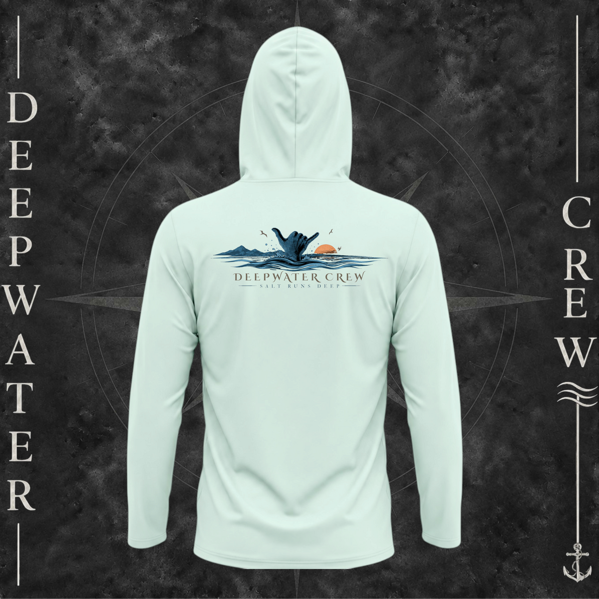 Mint Green Deepwater Crew Co. Salt Runs Deep UPF 50+ performance hoodie, back view with shaka hand, ocean waves, distant mountains, orange sunset, seabirds, and “Salt Runs Deep” lettering.