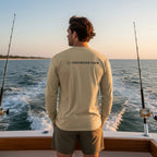 Deepwater Crew Co. tan long-sleeve performance tee with UPF sun protection, worn by a man on a boat.