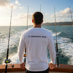 Deepwater Crew Co. white long-sleeve polyester performance tee with UPF 44+ sun protection, worn by a man on a boat.