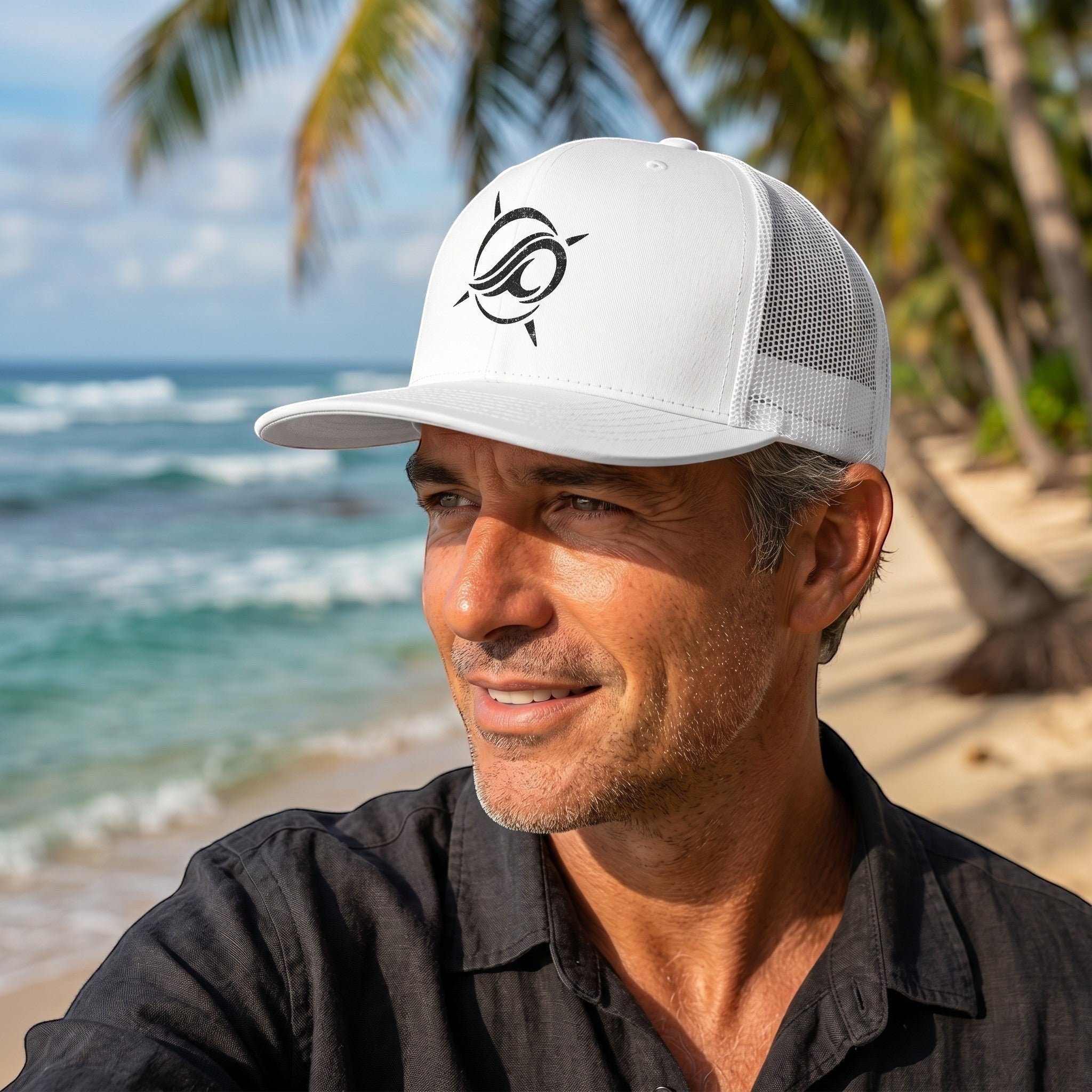 Man wearing a white Deepwater Crew Co. trucker cap with a black wave and compass logo on a sunny beach.